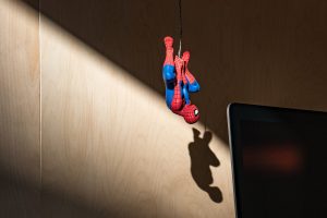 Une figurine de spiderman suspendue à un fil dans une chambre d'enfant